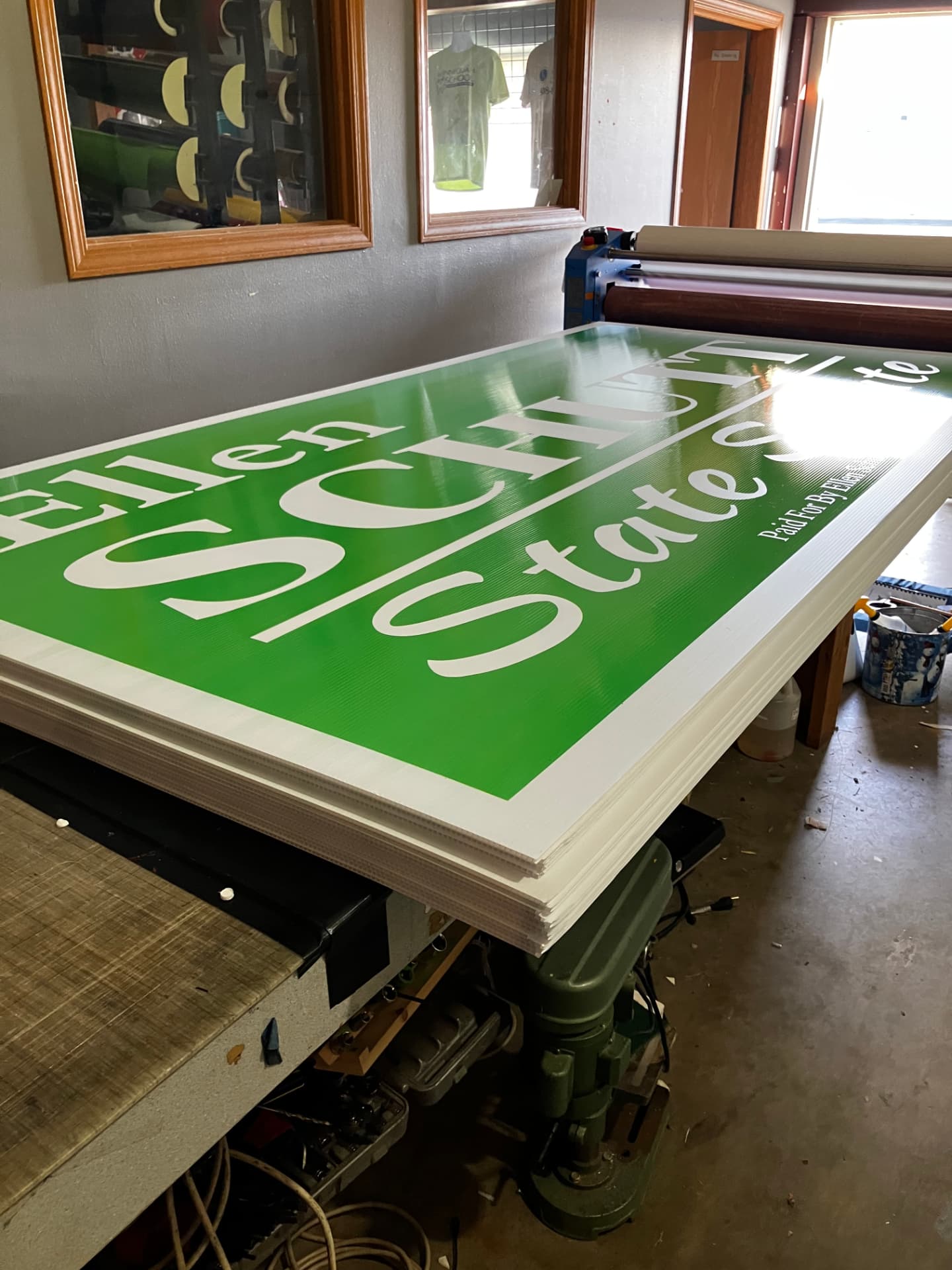 Freshly printed large-format Wisconsin campaign signs stacked on the press table